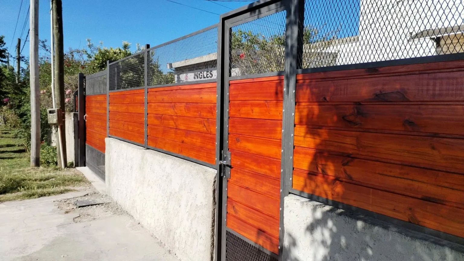 Cerramiento con madera y puerta peatonal integrada