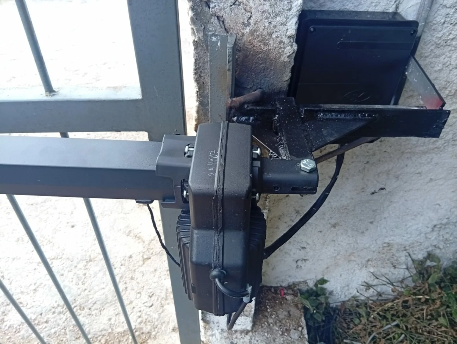 Brazo automático instalado en un portón